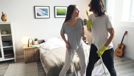 couple cleaning and dancing