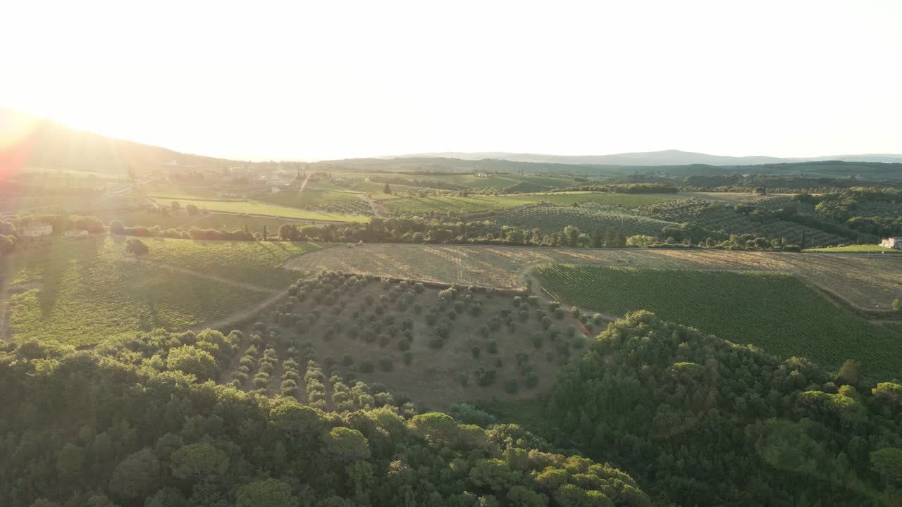 Drone footage of sunrise over the hills and vineyards of Tuscany.