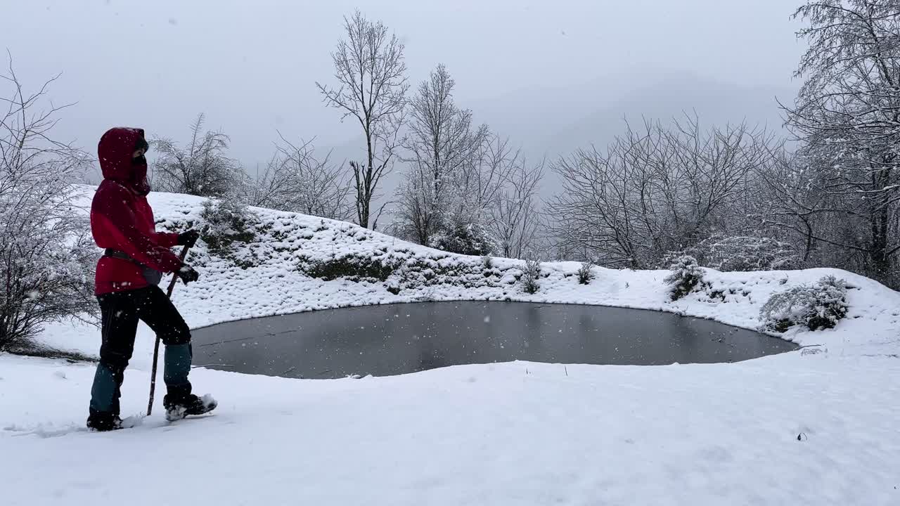 Woman wear red jacket hiking adventure in outdoor panoramic view of wonderful frozen lake winter forest countryside mountain snowfall nature activity scenic landscape peaceful in Iran freezing pond