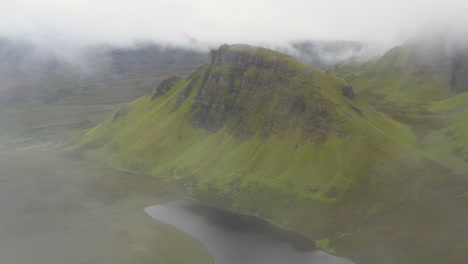 Drone-shot-coming-through-the-clouds-to-reveal-Quiraing-the-landslip-on-the-eastern-face-of-Meall-na-Suiramach-in-Scotland