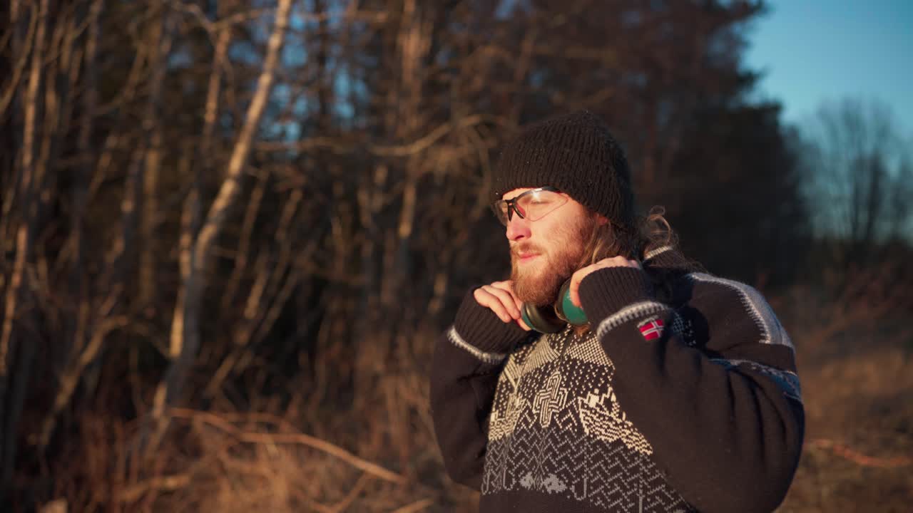 한 남자가 보호 안경과 귀막을 착용하고 있습니다. 중간 근접 사진입니다.