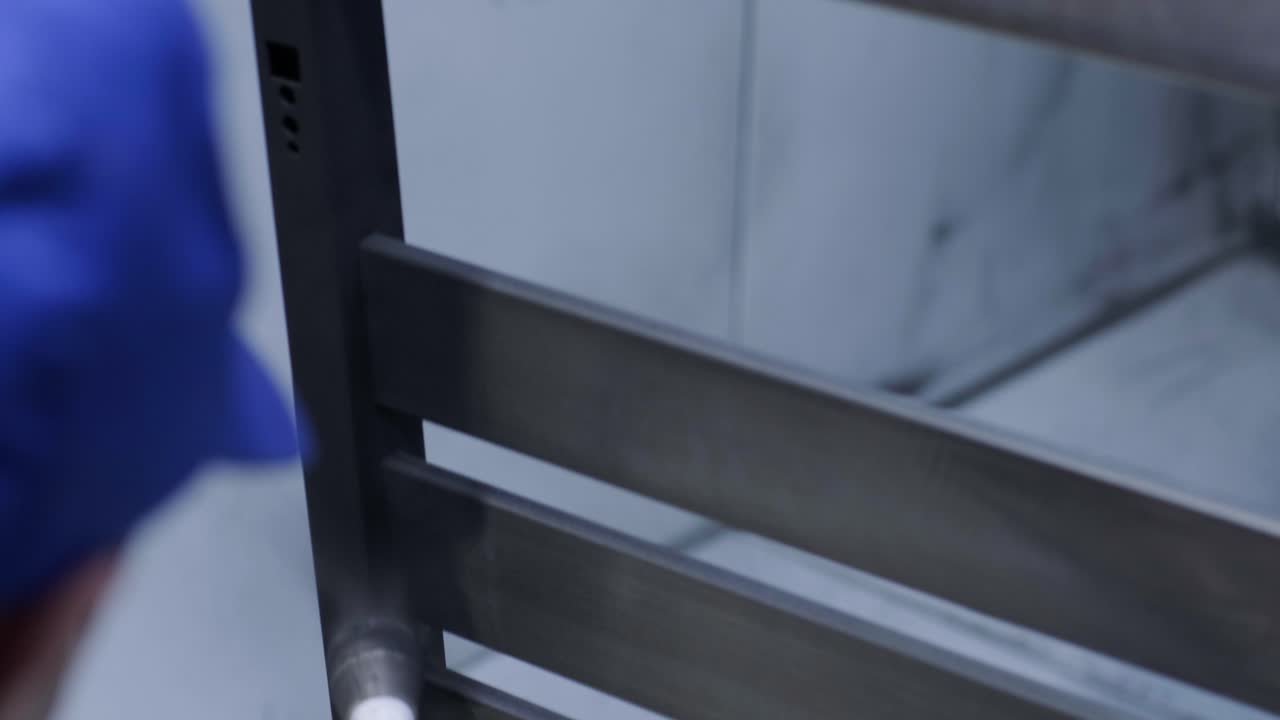 un trabajador pinta una estructura metálica de acero inoxidable con una pistola de pulverización de aerógrafo. método de pintura en seco.