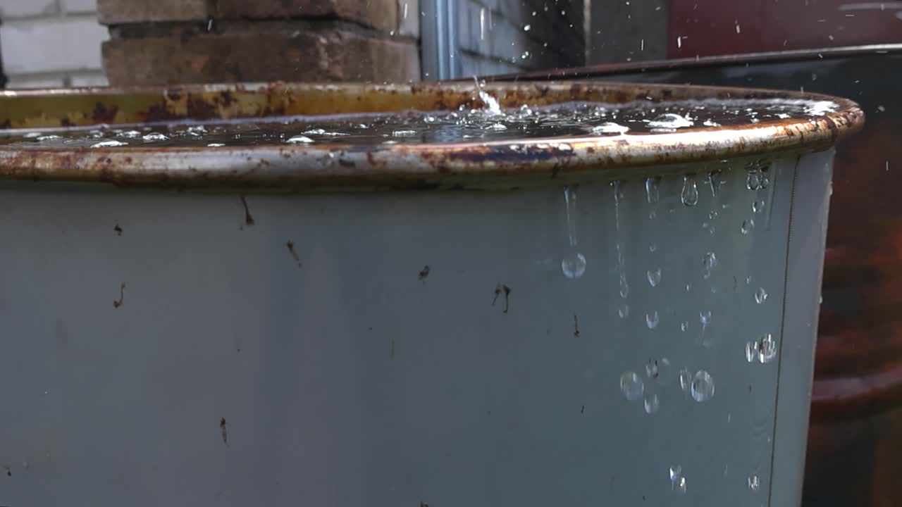 Water Dripping into a Rusty Metal Barrel