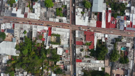 Aerial-birds-eye-overhead-top-down-view-of-urban-neighbourhood.-Cars-driving-in-streets-between-small-houses-with-flat-roofs.--Valladolid,-Mexico