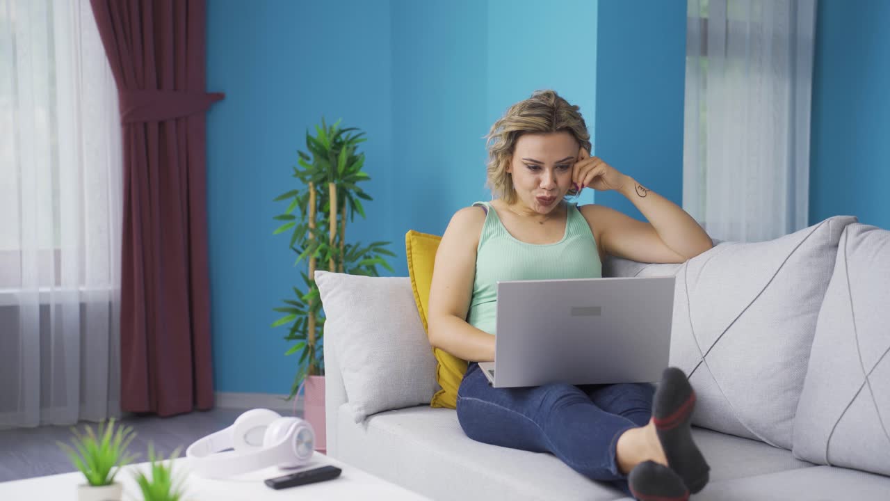 Woman watching movie on laptop with happy expression.