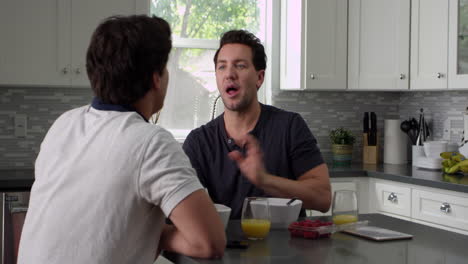 male gay couple talking at breakfast in their kitchen, shot on r3d