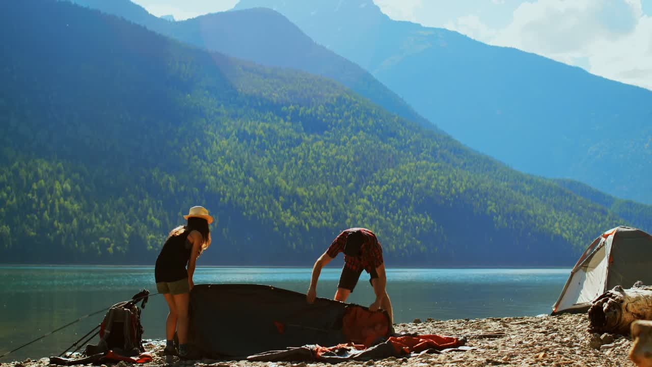 하이커 커플 이 강변 4k 근처 에 텐트 를 준비 하고 있다