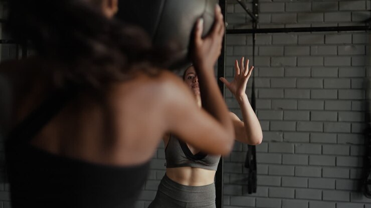 mujer trabajando en un gimnasio con una pelota de ejercicio