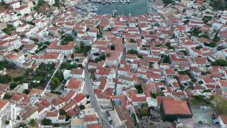 Aerial-drone-video-of-picturesque-port-and-main-village-of-Hydra-or-Ydra-island-with-beautiful-neoclassic-houses,-Saronic-gulf,-Greec