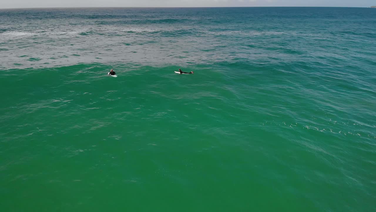 vista aérea de surfistas en busca de grandes olas, australia nublada - estática, disparo de drones