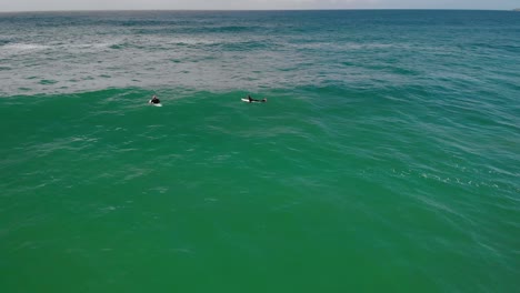 Vista-Aérea-De-Surfistas-En-Busca-De-Grandes-Olas,-Australia-Nublada---Estática,-Disparo-De-Drones