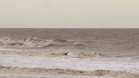 cold bleak looking winter waves breaking on to ingoldm musicells, skegness sandy beach