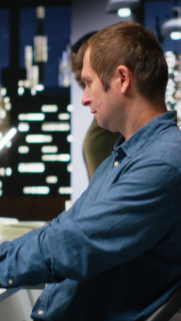 Vertical Video Portrait of male specialist in office uses CAD software and blueprints plan