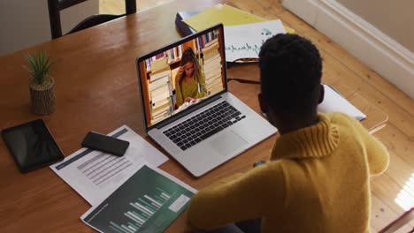 african american female teacher using laptop on video call with female student