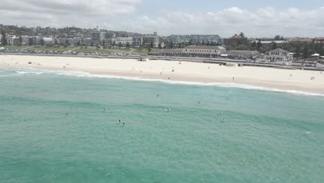 衝浪者坐在衝浪板上漂浮在藍海附近邦迪海灘 - 在邦迪,nsw,澳洲的熱門海灘