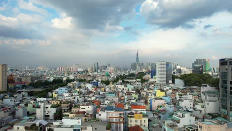 Breite-Eröffnungssequenz-In-Geringer-Höhe-Von-Ho-Chi-Minh-Stadt-Vietnam-In-Einem-örtlichen-Wohngebiet,-Umgeben-Von-Dicht-Besiedelten-Gebäuden-Und-Der-Skyline-Des-Wahrzeichens-81-In-Der-Ferne-An-Einem-Sonnigen-Tag