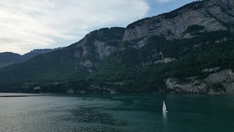 Escena-Tranquila-De-Yate-Navegando-En-El-Lago-Walensee-Adornado-Con-Montañas