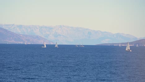 Beautiful-view-of-sailboats-in-Adriatic-sea-with-mountainous-coast-in-the-background
