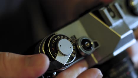 man takes a photo with a vintage 35mm film camera and advances film