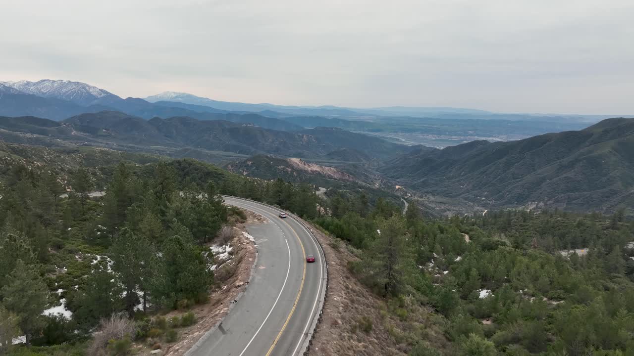 conduciendo en una curva por la montaña del gran oso ca con una vista completa de las montañas y el cielo en el fondo