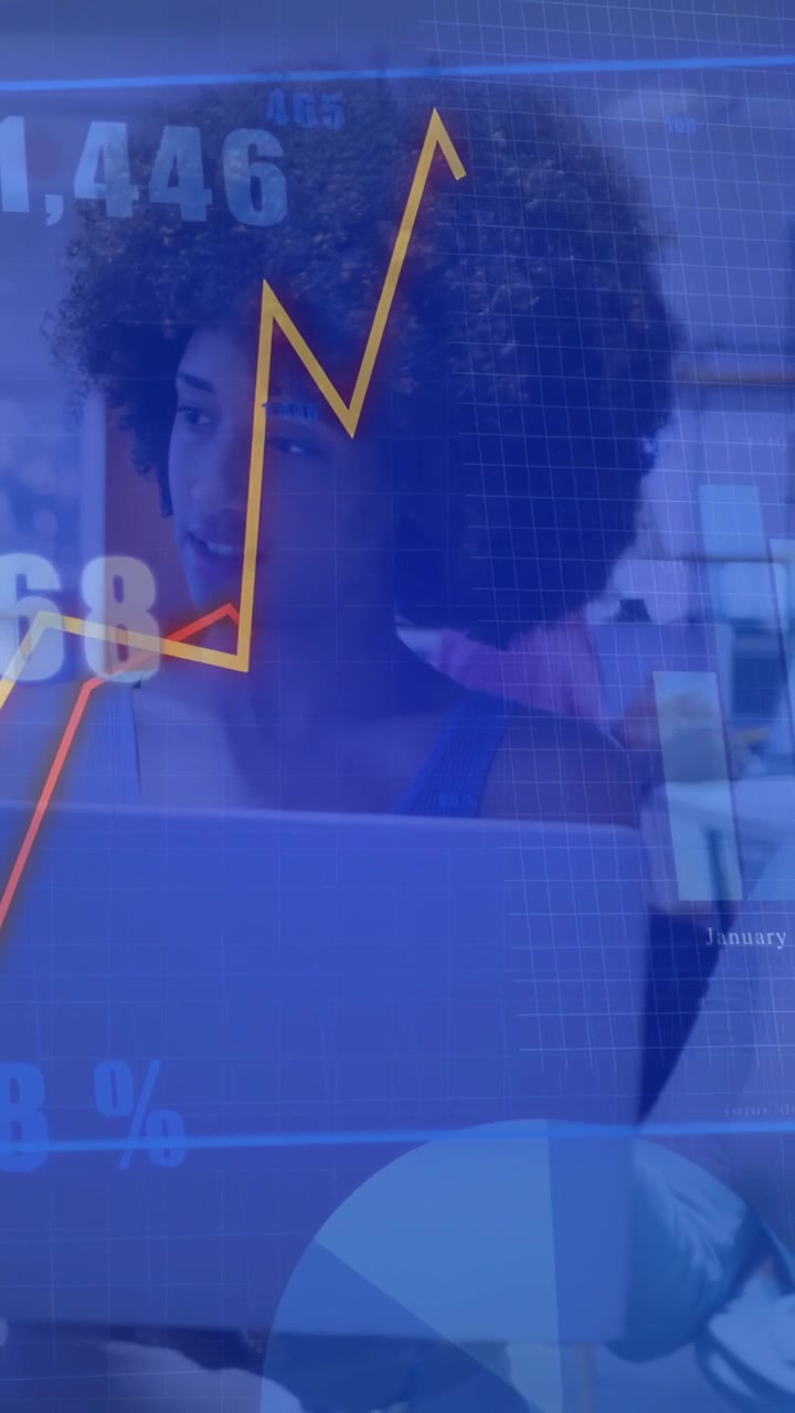 Vertical video: Woman at laptop viewing data overlay causing animated charts and rates for business