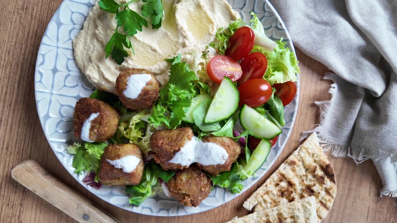 Falafel tradizionale servito con hummus e insalata fresca.