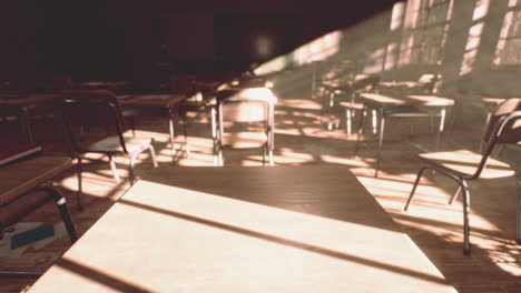 view to classroom with tables and small blackboard and grungy walls