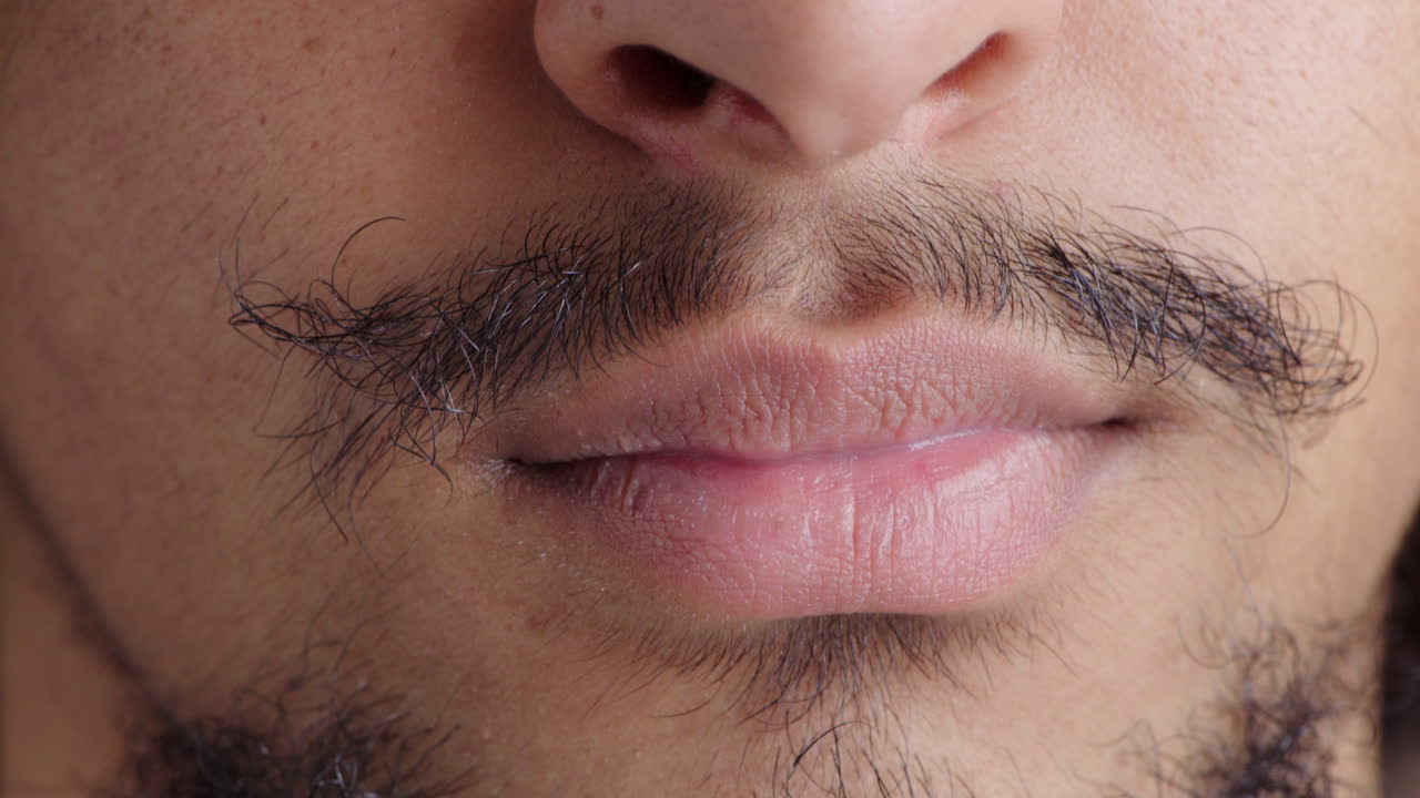 primer plano de una boca masculina sonriendo con una oscuridad desordenada