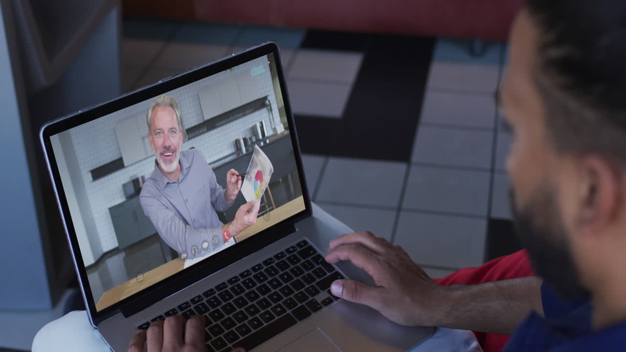 hombre de oriente medio teniendo una videollamada con un colega masculino en una computadora portátil