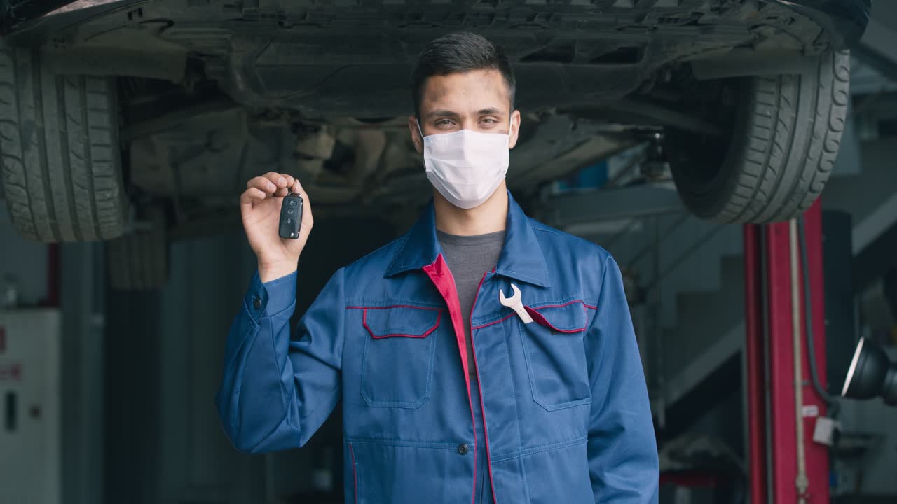 mecánico con llave de coche en un garaje
