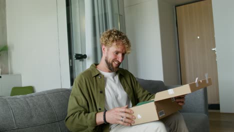 man unboxing a package at home