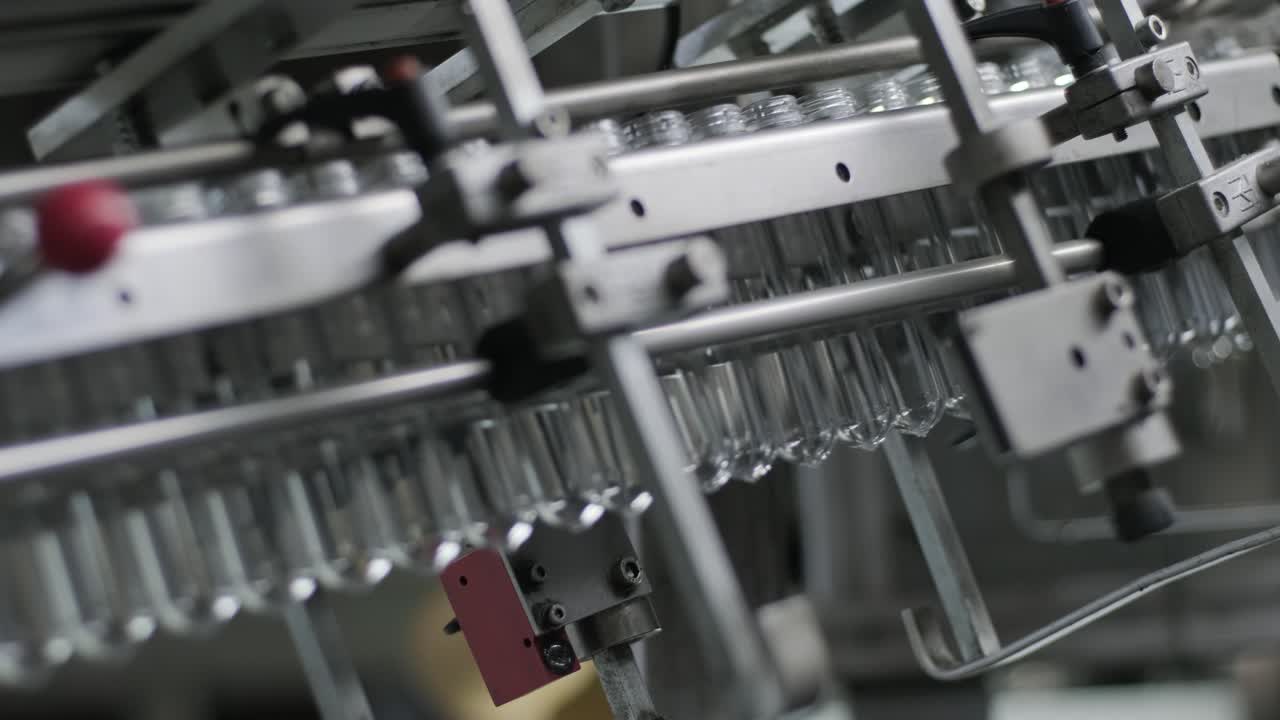 Automatic filling machine pours water into plastic PET bottles at modern beverage plant