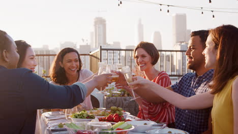 friends gathered on rooftop terrace for meal with city skyline in background