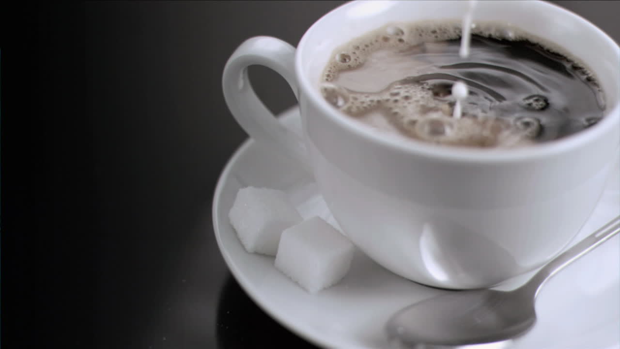 молоко течет в супер медленном движении в чашке