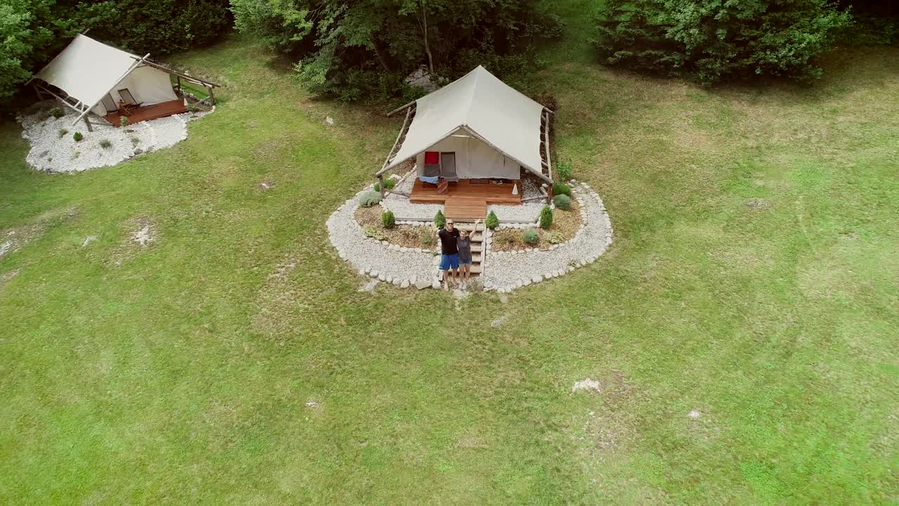 vista aérea de una pareja de pie frente a una zona de descanso en un campamento.