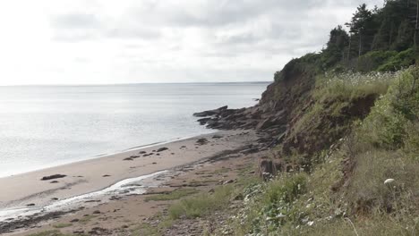 Red-Sand-Beach-near-Cliff-and-Rocks