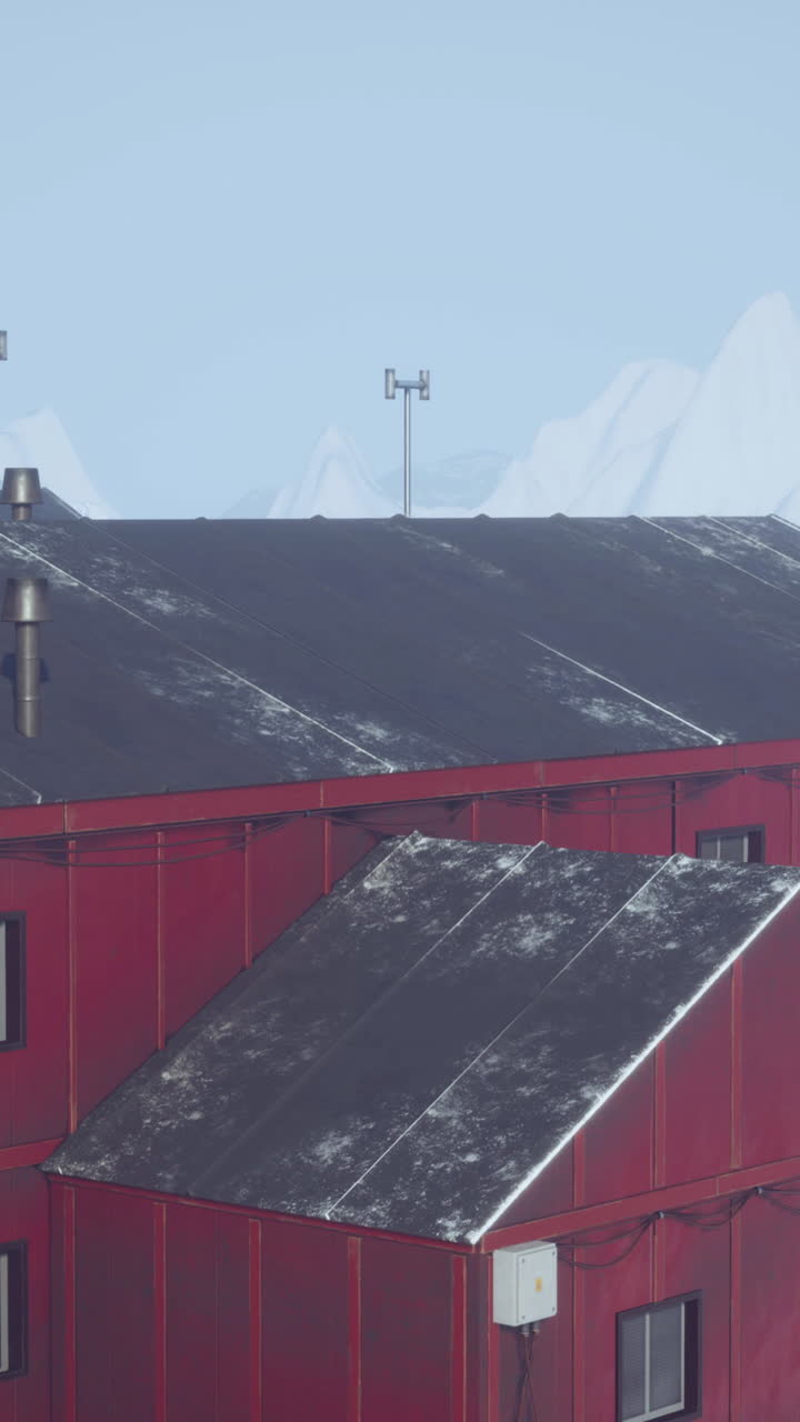 edificio rojo con montañas nevadas en el fondo