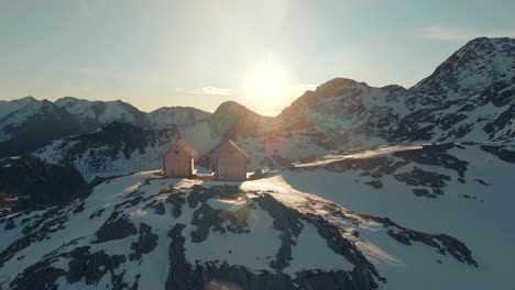 two wooden huts in the italian alps at sunrise