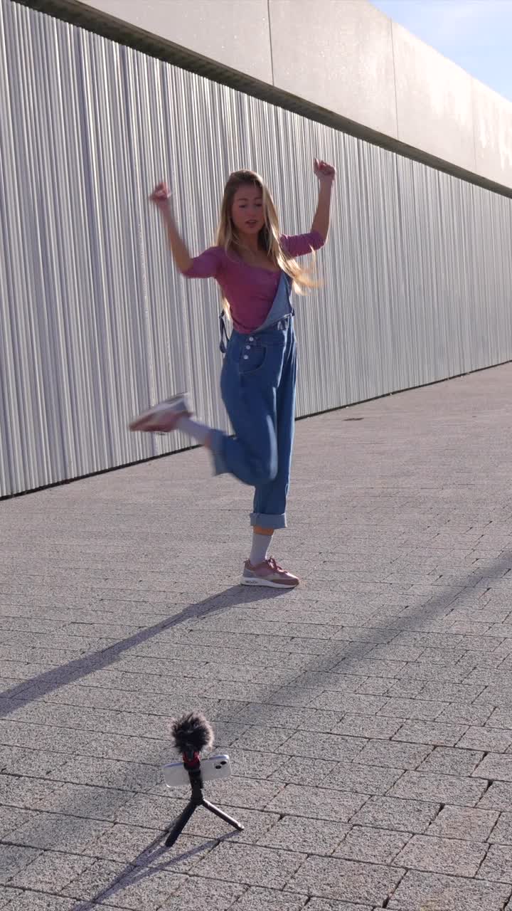 Woman dancing in the street while recording a vlog