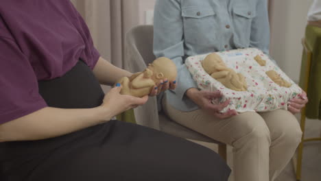 pregnant woman holding toy baby