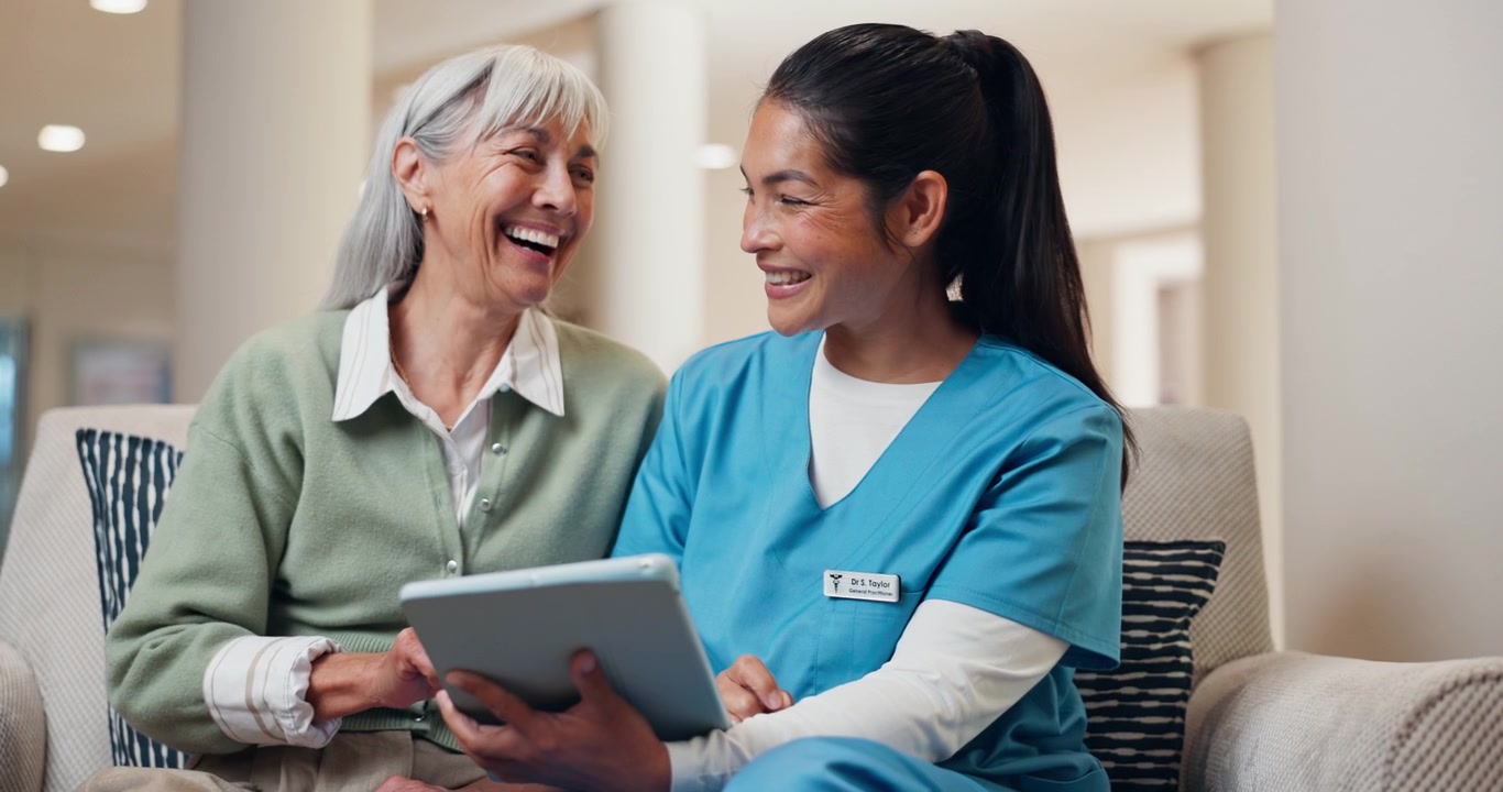 Nurse and Senior Woman Using Tablet Together in Care Facility