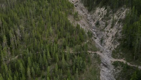 Rápido-Movimiento-De-Empuje-De-Un-Dron-De-4k-Hacia-Una-Magnífica-Montaña-En-El-País-De-Kananaskis-Que-Revela-A-Un-Excursionista-Que-Baja-Por-La-Empinada-Colina-Rocosa