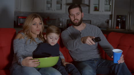 Zeitlupenaufnahme-Einer-Familie,-Die-Auf-Dem-Sofa-Sitzt-Und-Fernsieht