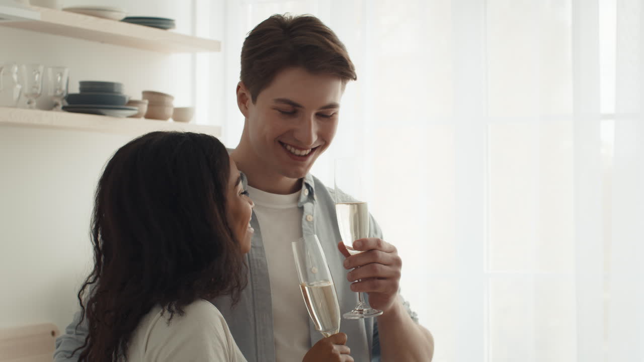 Coppia che festeggia con champagne in cucina