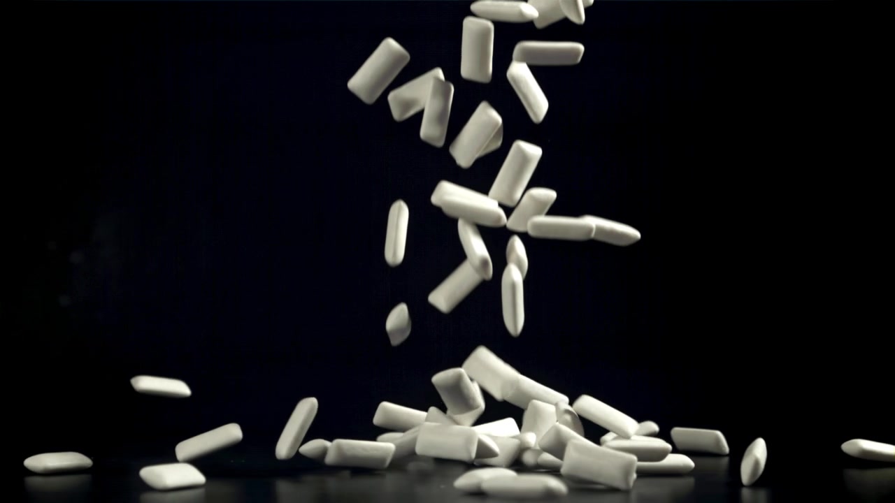 Palline di gomma da masticare bianche che cadono al rallentatore