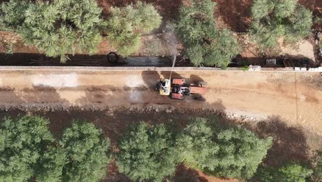 Imágenes-Aéreas-De-Arriba-Hacia-Abajo-Siguiendo-A-Un-Tractor-Que-Rocía-Producto-Sobre-Olivos-En-Una-Granja-En-El-Sur-De-Italia.