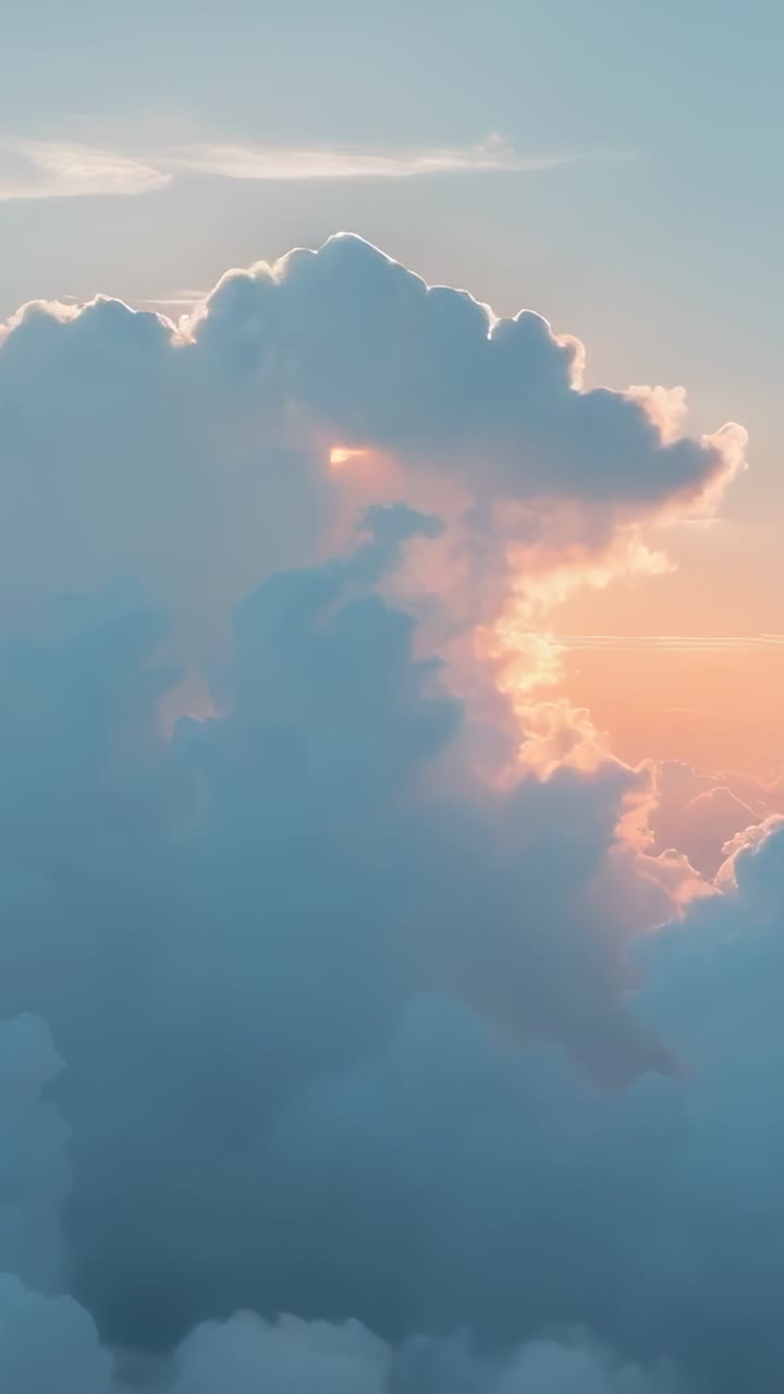 Vertical video: Sun emerging behind cumulus cloud scattering wisps, blurring glow above cloud deck