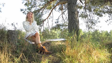a woman paints on a canvas in the forest happy artist outdoors bright sunlight in the frame - a woman paints on a canvas in the forest. happy artist outdoors. bright sunlight in the frame