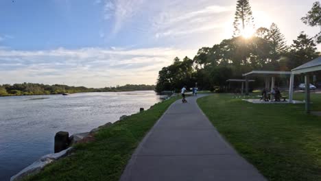 people walking along lakeside path at sunset