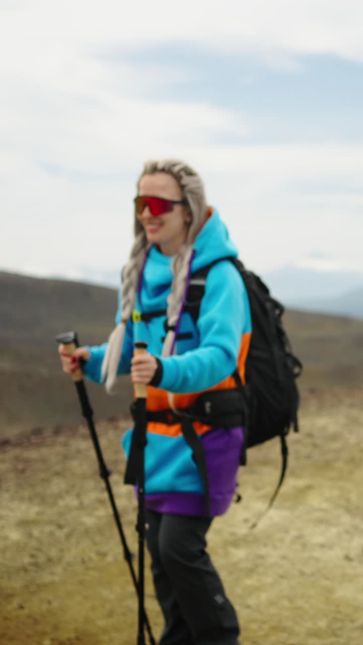 Donne felici in escursione con zaini e bastoncini da trekking in montagna